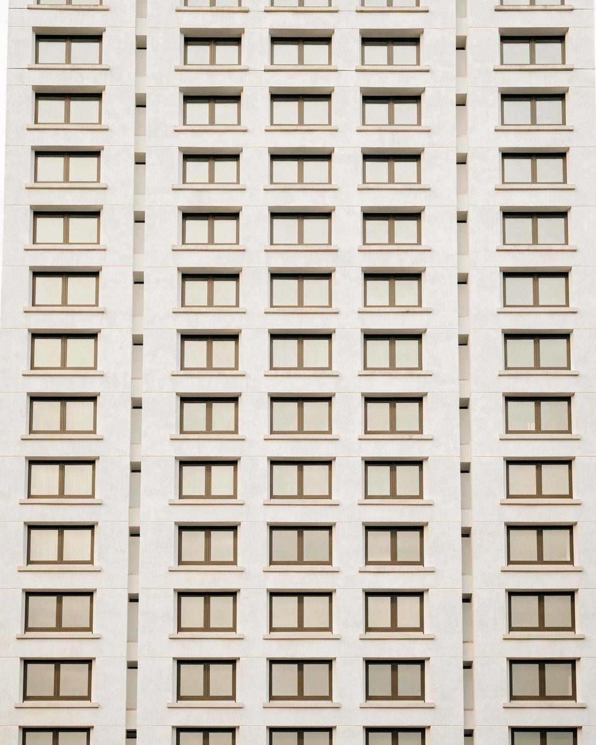 Wohnhausfassade mit streng gerasterten Fensterreihen über zehn Geschosse